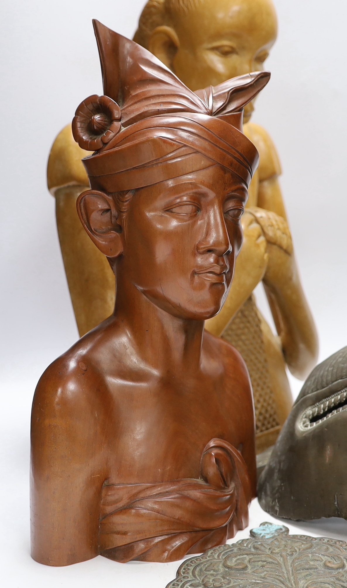 A West African carving of a girl, and a Balinese bust of a man together with an Indonesian metal mask and black lacquered spoon, mask 38cm high